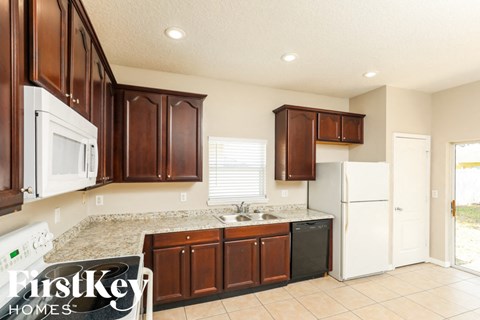 A kitchen with brown cabinets and a white fridge.