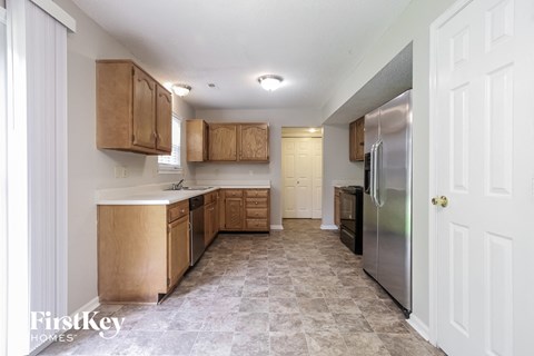 A kitchen with wooden cabinets and a tiled floor.