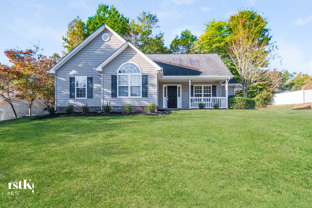 A house with a grey roof and a white fence in the background.