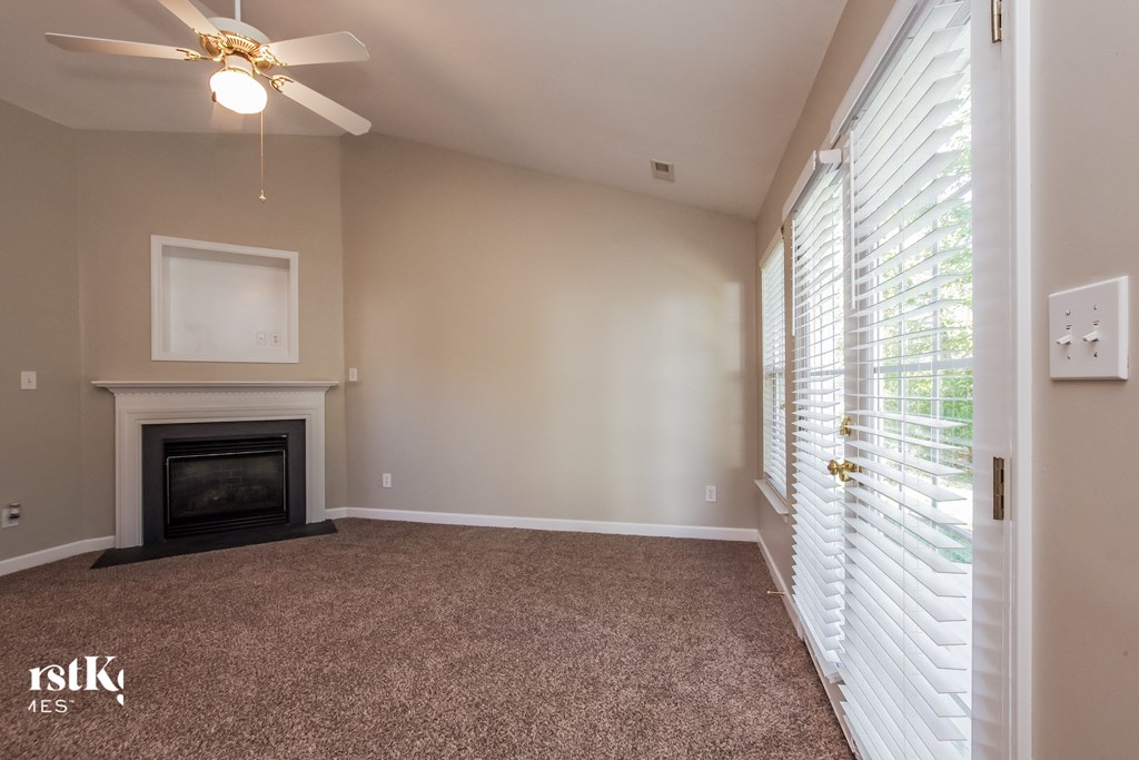 A room with a fireplace and a ceiling fan.