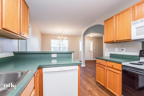 A kitchen with wooden cabinets and green countertops.