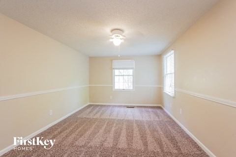 a spacious living room with carpet and a window