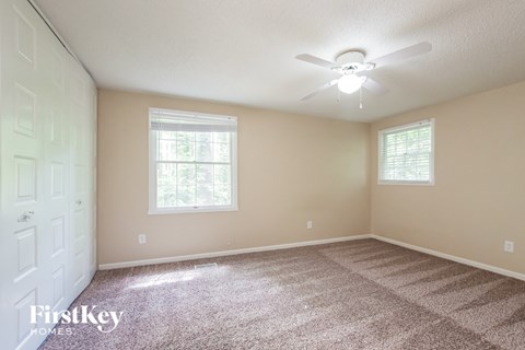 a bedroom with carpet and a ceiling fan