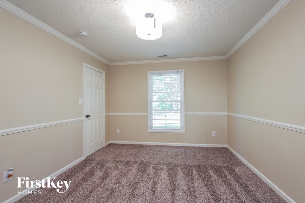 an empty dining room with carpet and a white door