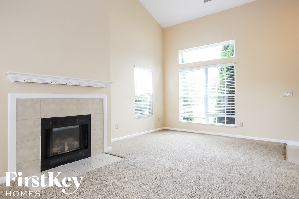 A room with a fireplace and carpeting.