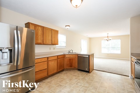 A kitchen with wooden cabinets and a stainless steel refrigerator.