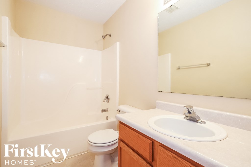 A white toilet sits next to a sink in a bathroom.