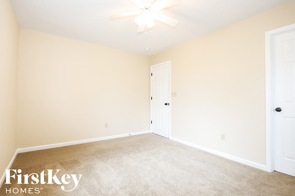 A room with a fan and two doors.