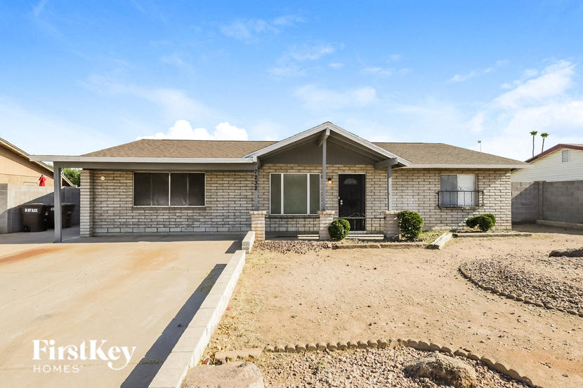 a brick house with a dirt yard in front of it