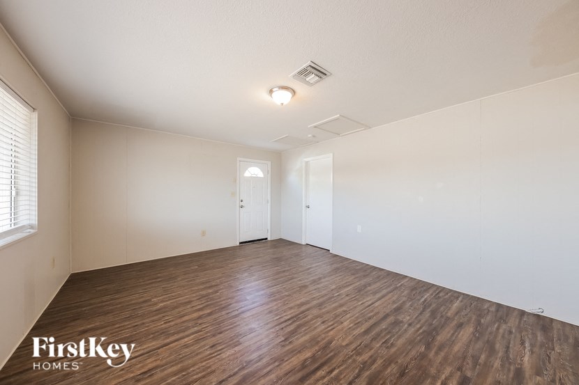 a living room with a hard wood floor and white walls