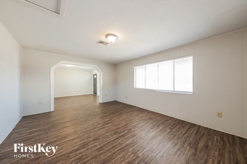 the living room and dining room with wood floors and white walls