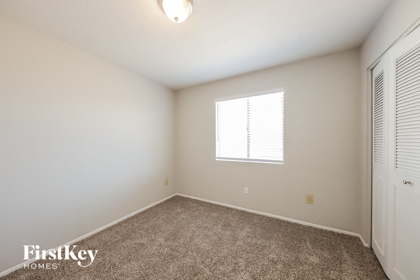 a spacious room with carpet and a window