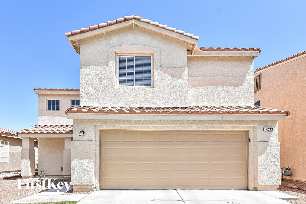 A house with a beige garage door is for sale.