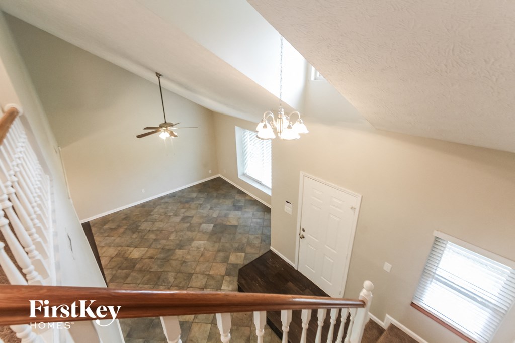 the view from the top of the stairs looking into the living room and dining room