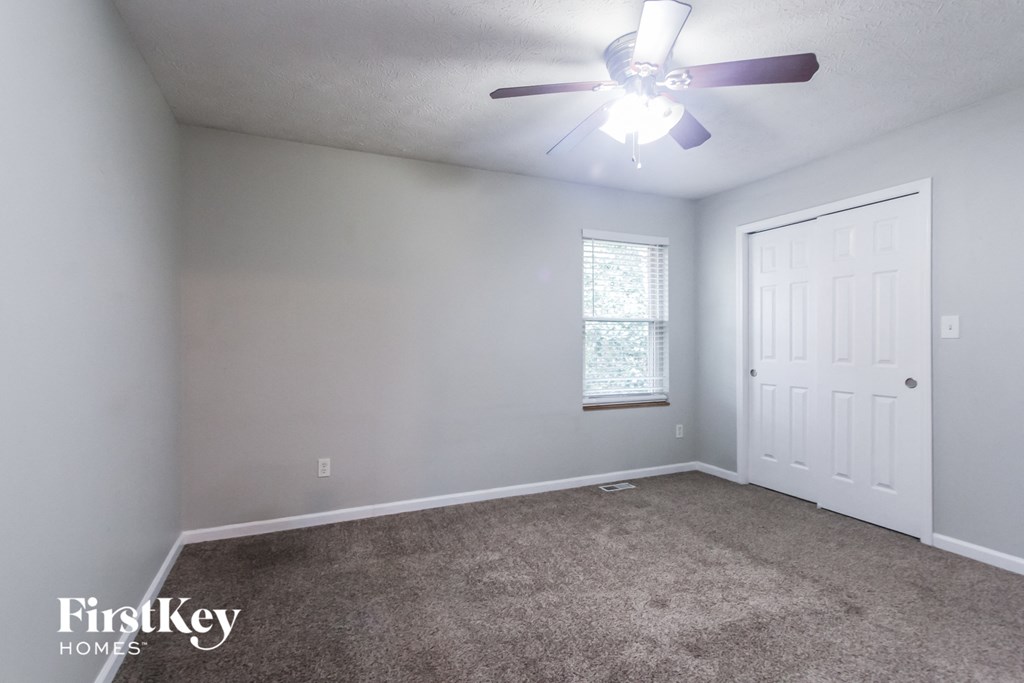 a bedroom with a ceiling fan and a white door