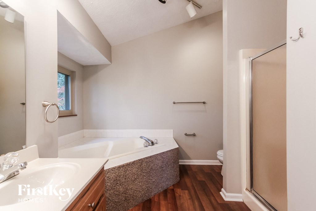 a bathroom with a tub and a shower and a sink