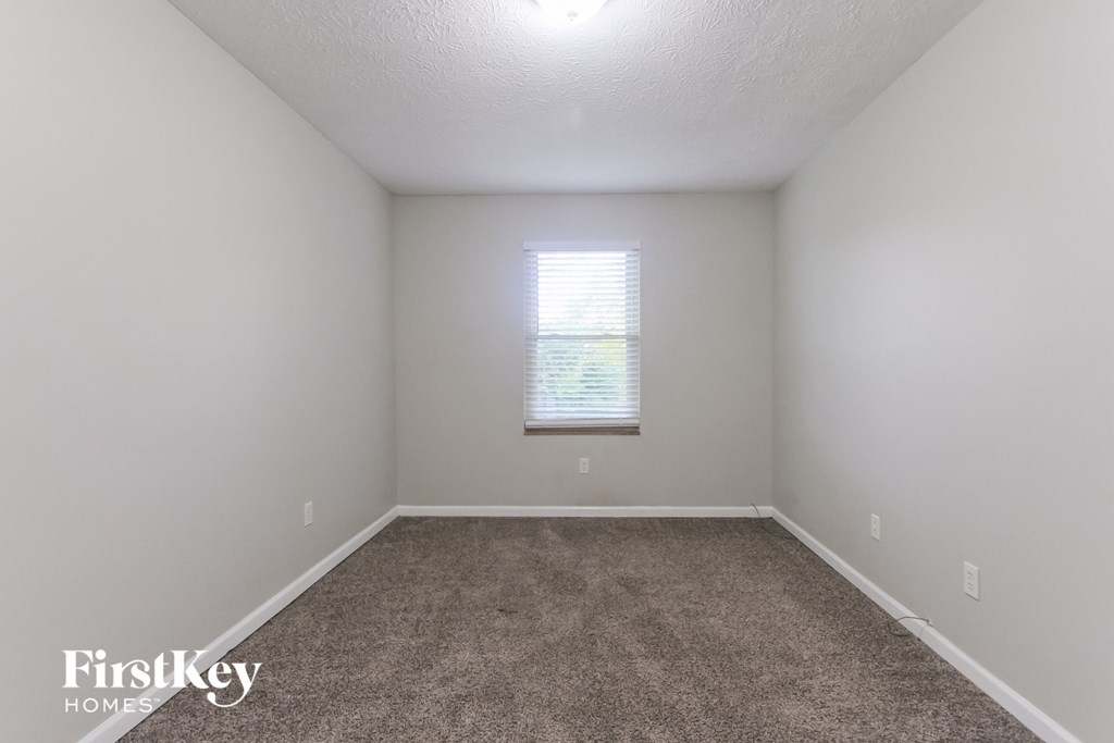 a empty room with carpet and a window
