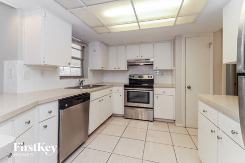 a kitchen with white cabinets and stainless steel appliances