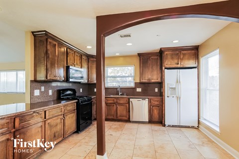 A kitchen with wooden cabinets and a white refrigerator.