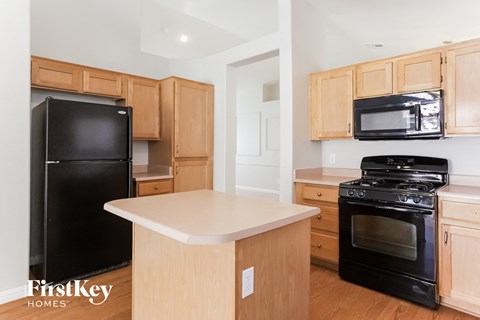 A kitchen with wooden cabinets and black appliances.