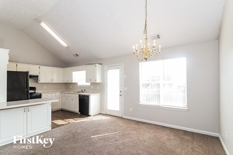 A well lit kitchen with a fridge, dishwasher and a sink.