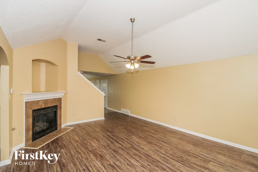 a living room with a fireplace and a ceiling fan