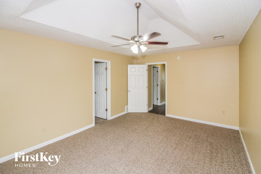 an empty living room with a ceiling fan