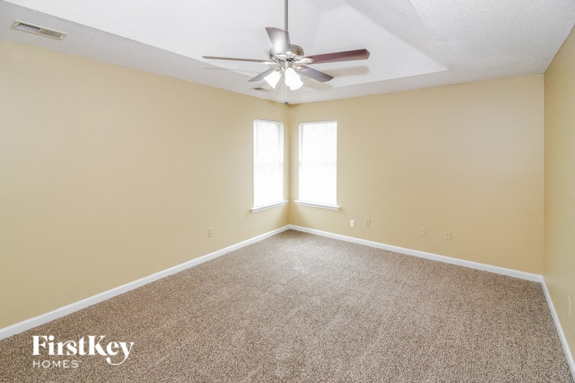 a empty living room with a ceiling fan