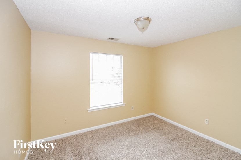 an empty room with a window and carpet