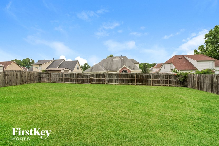 a backyard with a fence and a green lawn