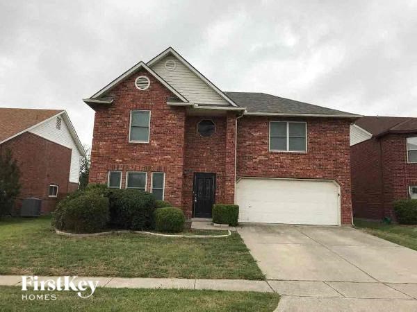 A brick house with a garage door is for sale.