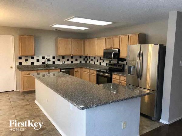 A kitchen with granite countertops and stainless steel appliances.