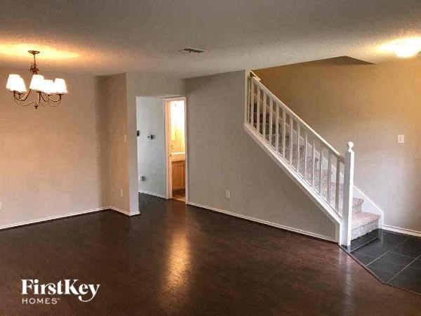 A spacious room with a staircase leading to the second floor.