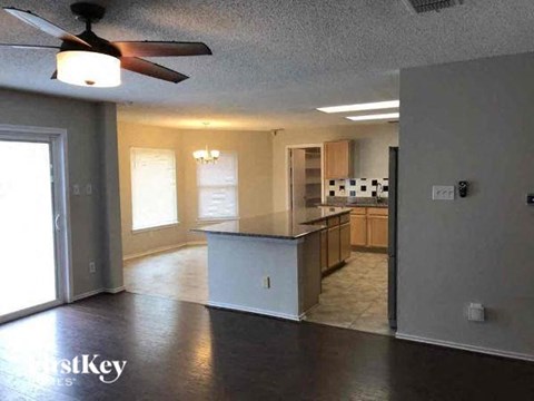 A kitchen with a counter and a fan on the ceiling.