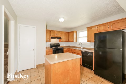 A kitchen with wooden cabinets and black appliances.