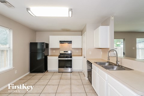 a kitchen with white cabinets and black appliances