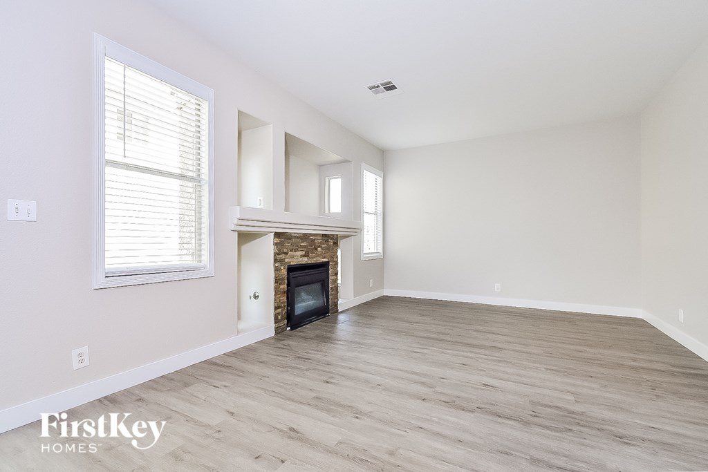 a living room with a fireplace and wooden floors