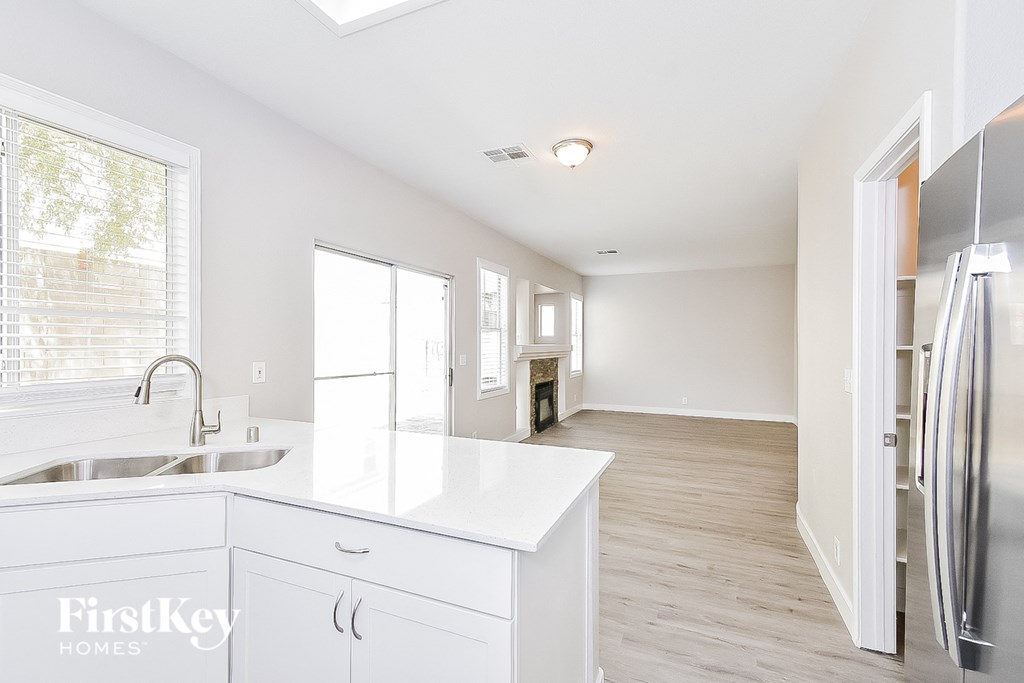 a white kitchen with stainless steel appliances and a white counter top