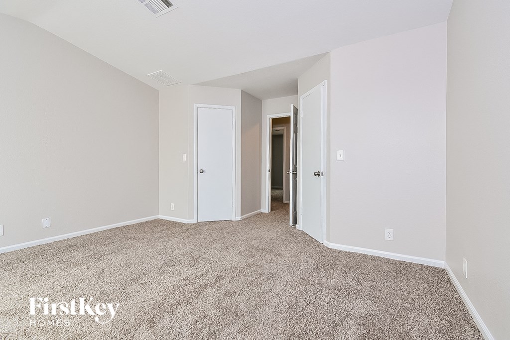 a spacious living room with carpeting and white walls
