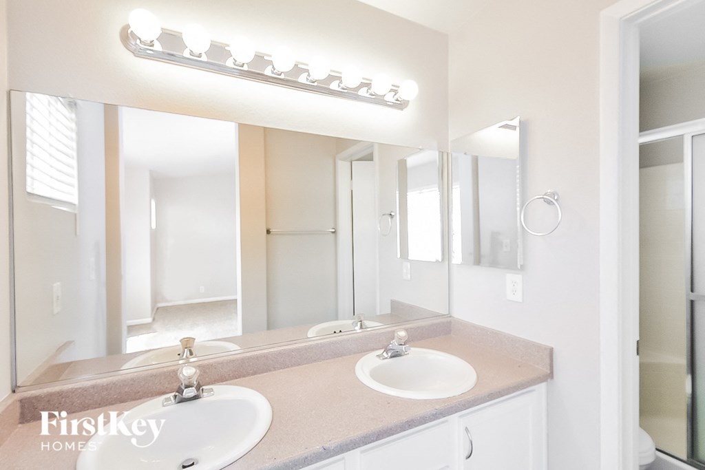 a bathroom with two sinks and a large mirror