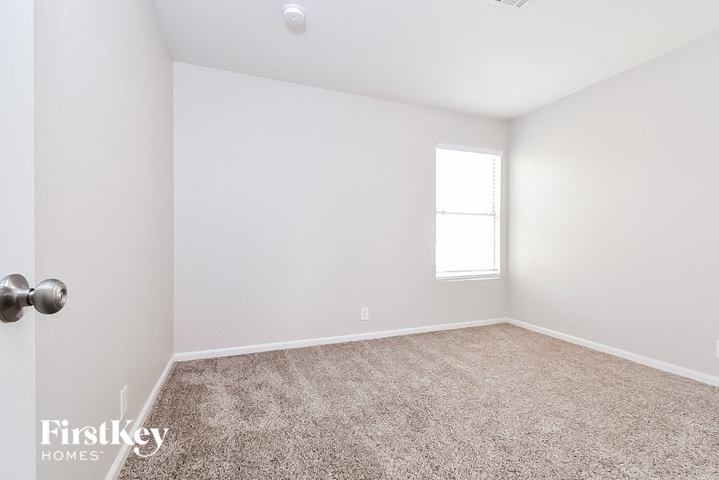an empty room with carpet and a window