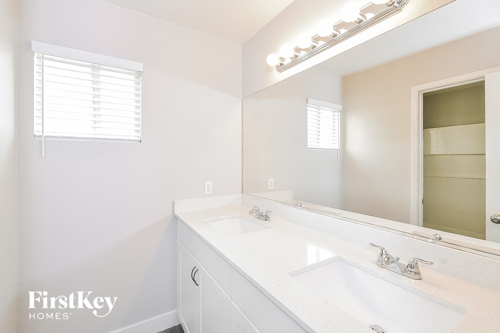 a white bathroom with a sink and a mirror