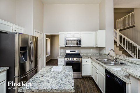 A kitchen with granite countertops and stainless steel appliances.
