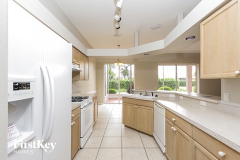 A kitchen with a white refrigerator and wooden cabinets.