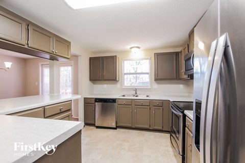 A kitchen with a refrigerator on the right side.