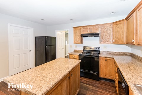 A kitchen with wooden cabinets and a granite countertop.