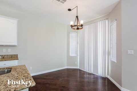 a kitchen with white blinds and a window and a counter top with a sink