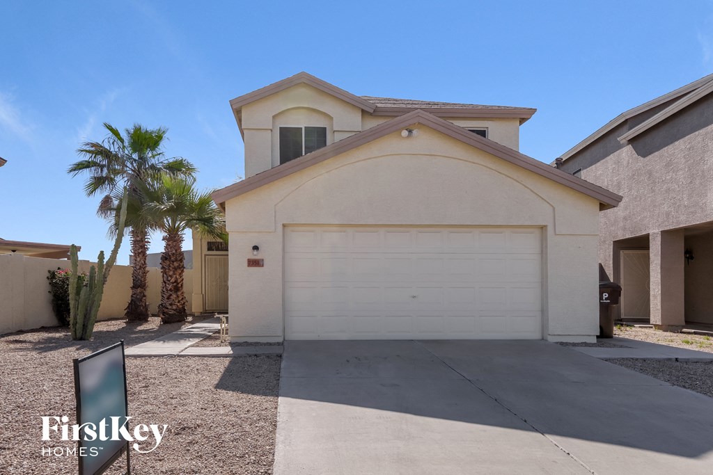 a house with a white garage door and palm trees