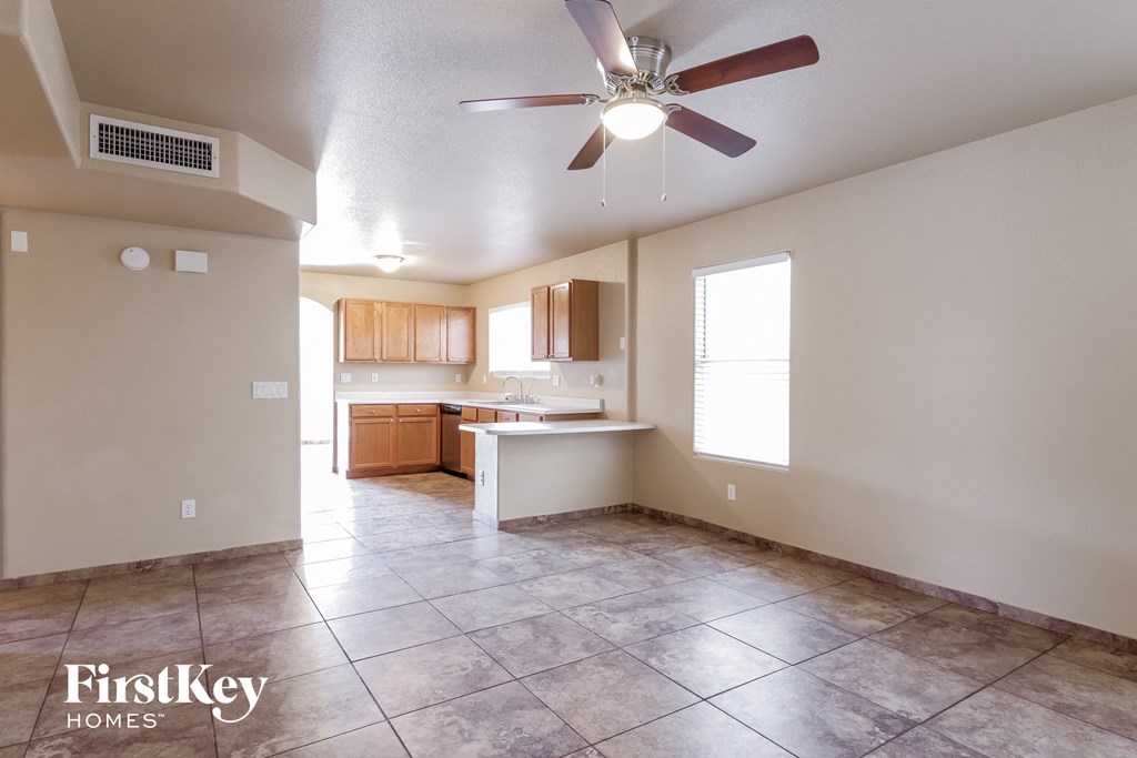 an empty kitchen with a ceiling fan and tile floor
