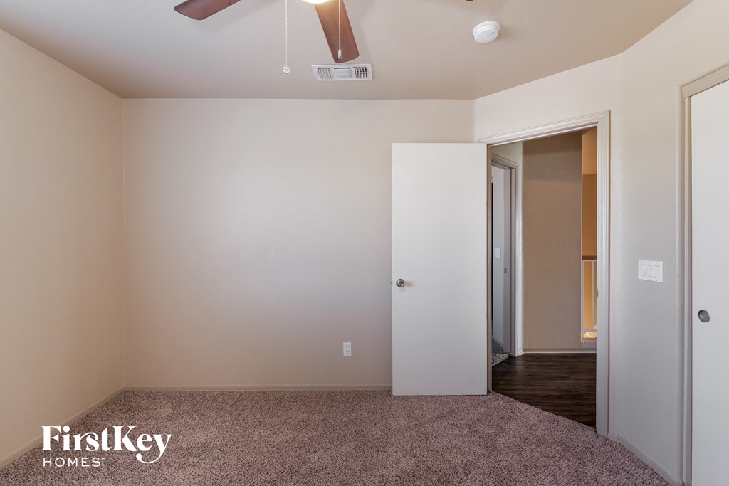 a bedroom with a door to a closet and a ceiling fan